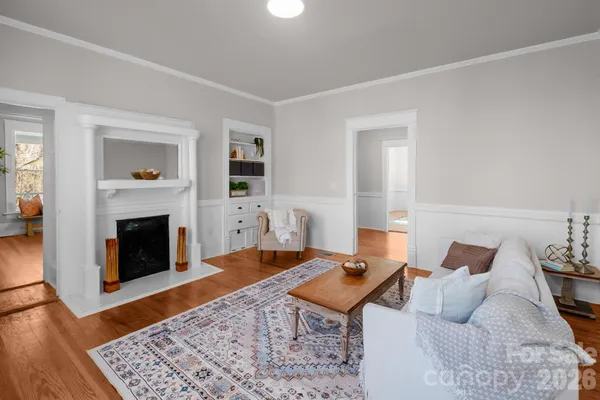 a living room with furniture a fireplace and wooden floor