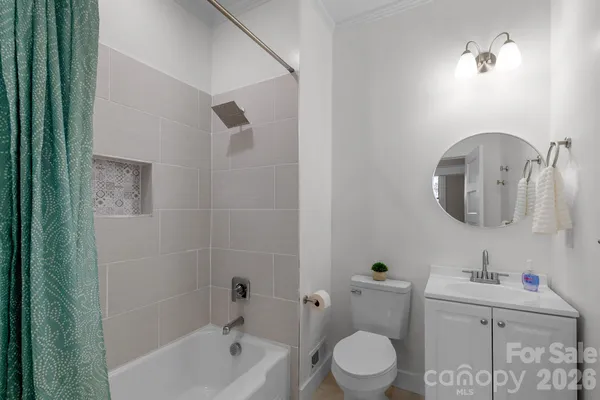a bathroom with a toilet a sink a mirror and bathtub