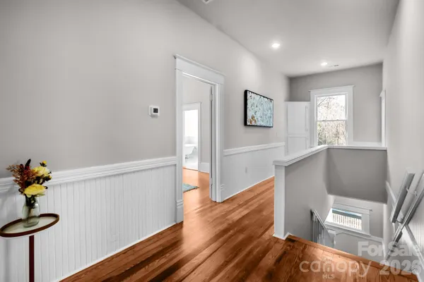 a view of hallway with furniture and wooden floor