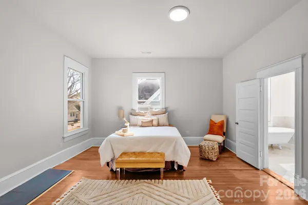 a bedroom with a bed and wooden floor