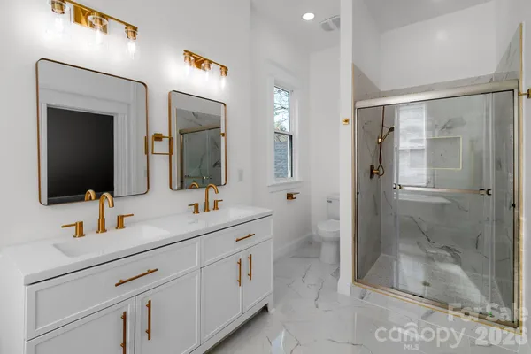 a bathroom with a double vanity sink mirror and shower