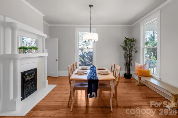 a dining room with furniture a chandelier and wooden floor