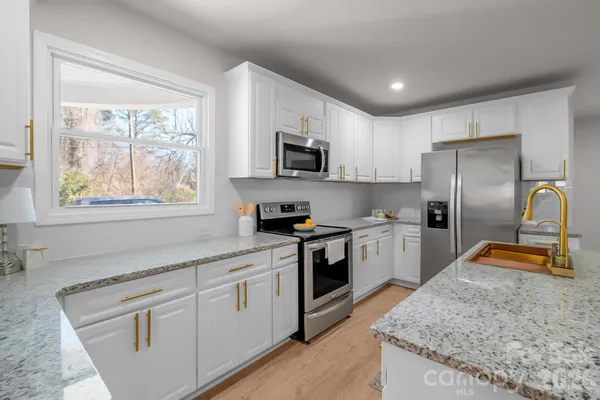 a kitchen with white cabinets and stainless steel appliances