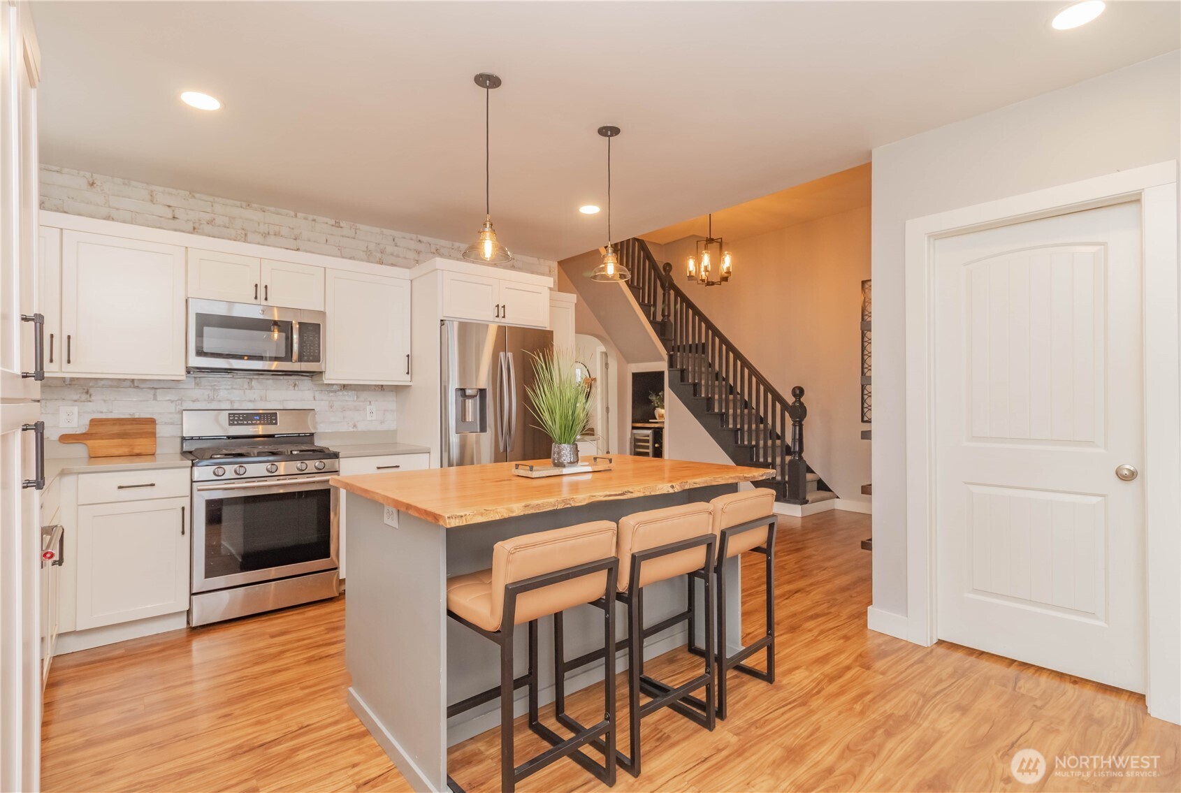 404 Factory Street Southeast Orting, WA 98360 - Photo 11 of 39 a kitchen with stainless steel appliances kitchen island a hardwood floor and a view of living room