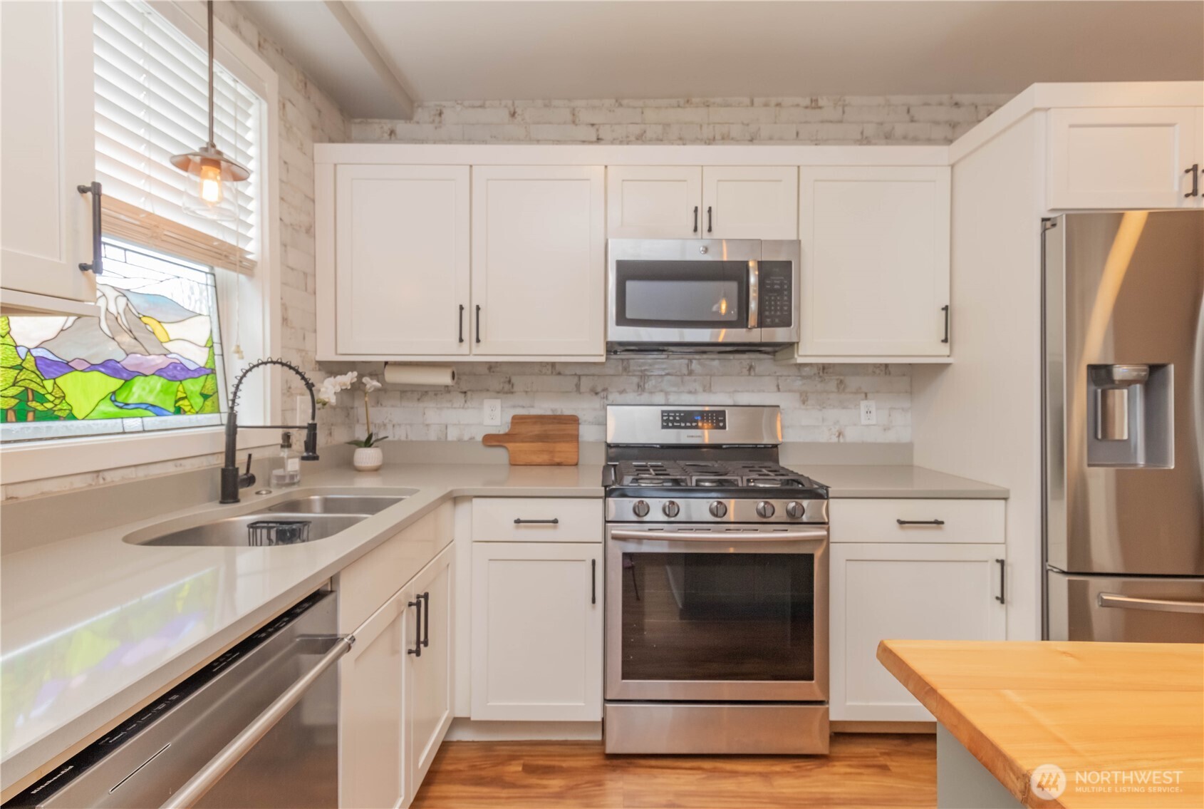 404 Factory Street Southeast Orting, WA 98360 - Photo 12 of 39 a kitchen with stainless steel appliances a stove sink and refrigerator