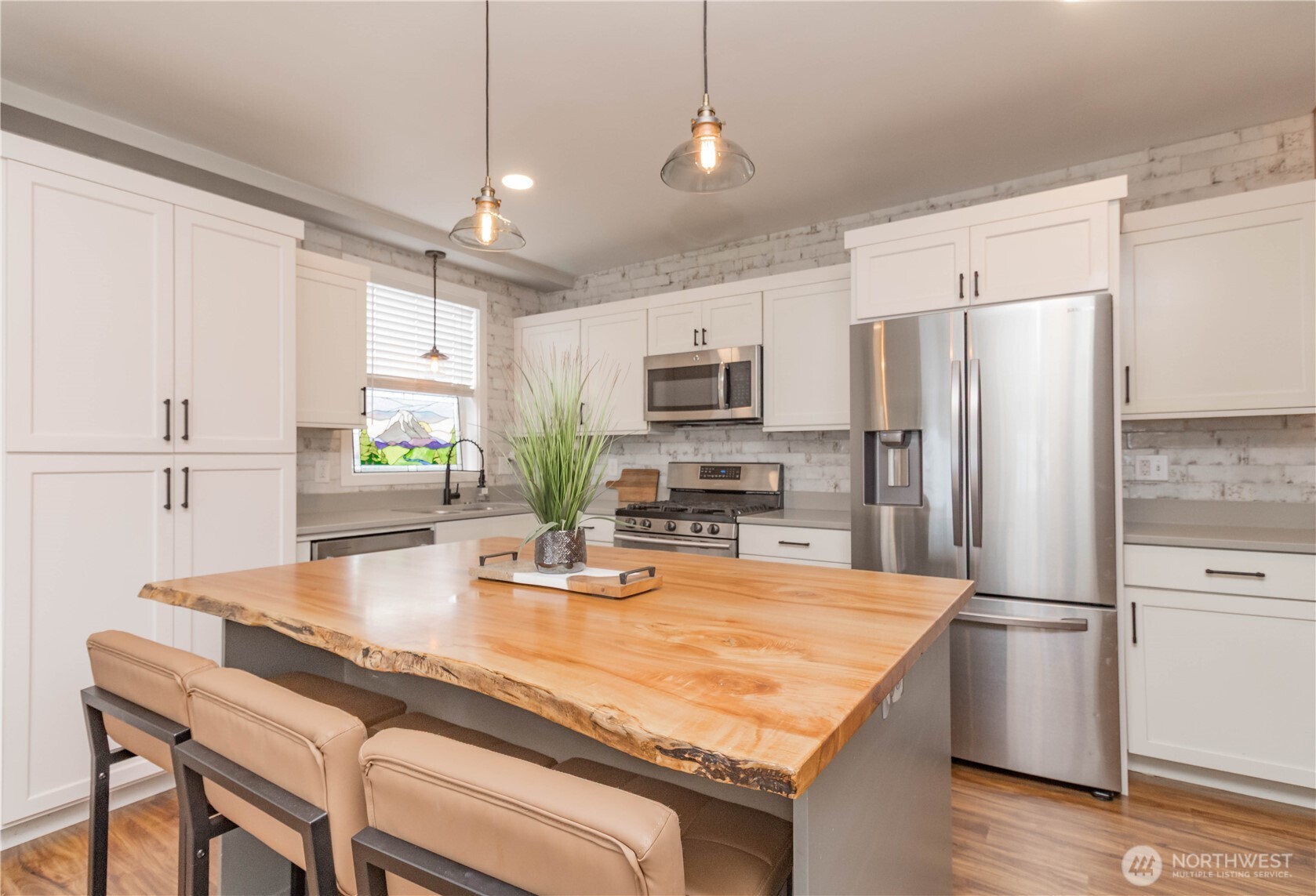 404 Factory Street Southeast Orting, WA 98360 - Photo 13 of 39 a kitchen with kitchen island a refrigerator stove microwave and cabinets