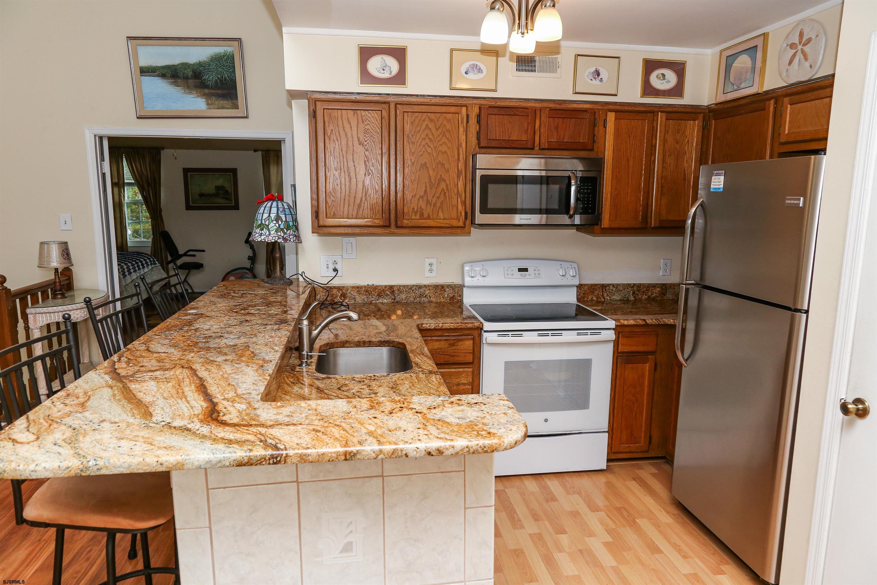 340 Seashell Lane Brigantine, NJ 08203 - Photo 14 of 29 a kitchen with granite countertop a refrigerator stove and microwave