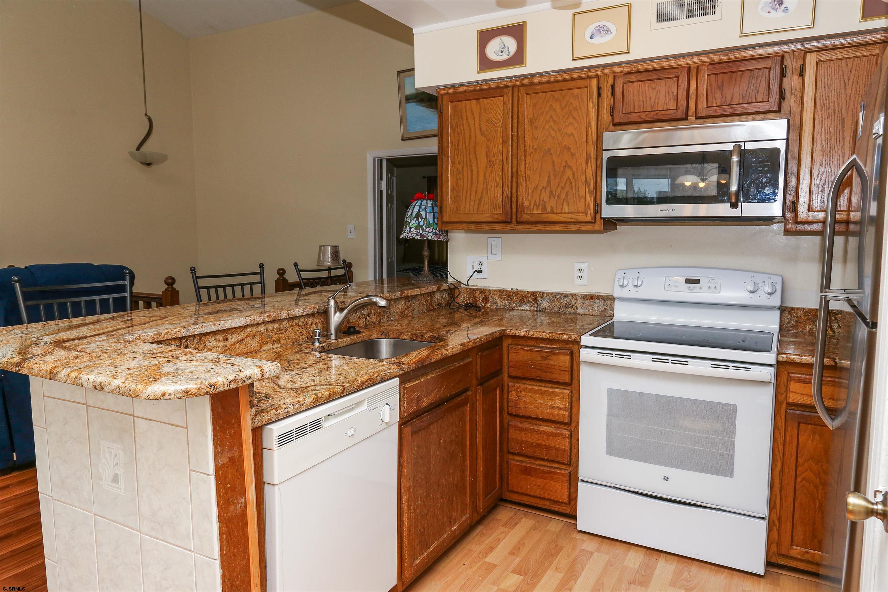 340 Seashell Lane Brigantine, NJ 08203 - Photo 15 of 29 a kitchen with stainless steel appliances granite countertop a stove a sink and a microwave