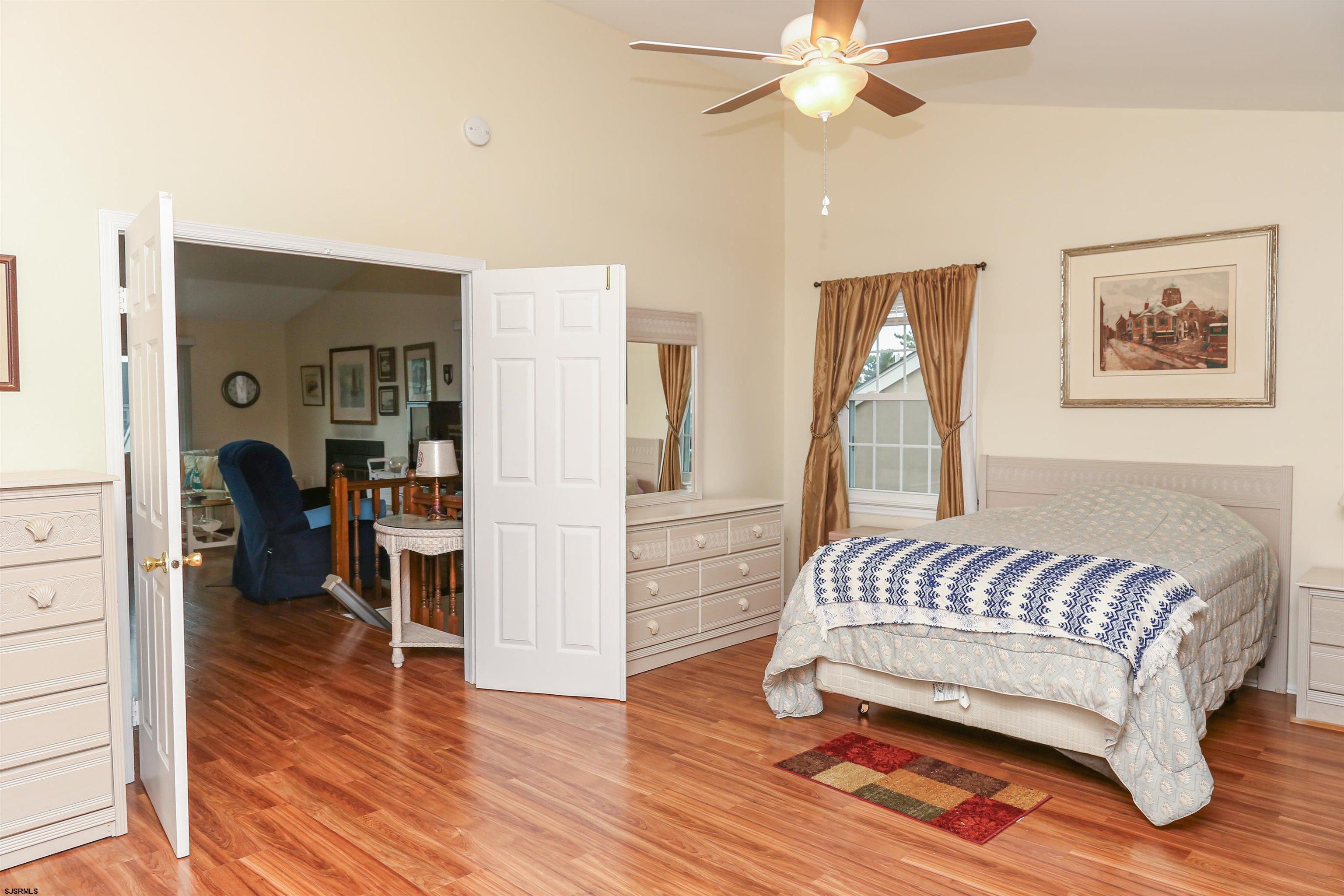 340 Seashell Lane Brigantine, NJ 08203 - Photo 22 of 29 a bedroom with a bed and a chandelier