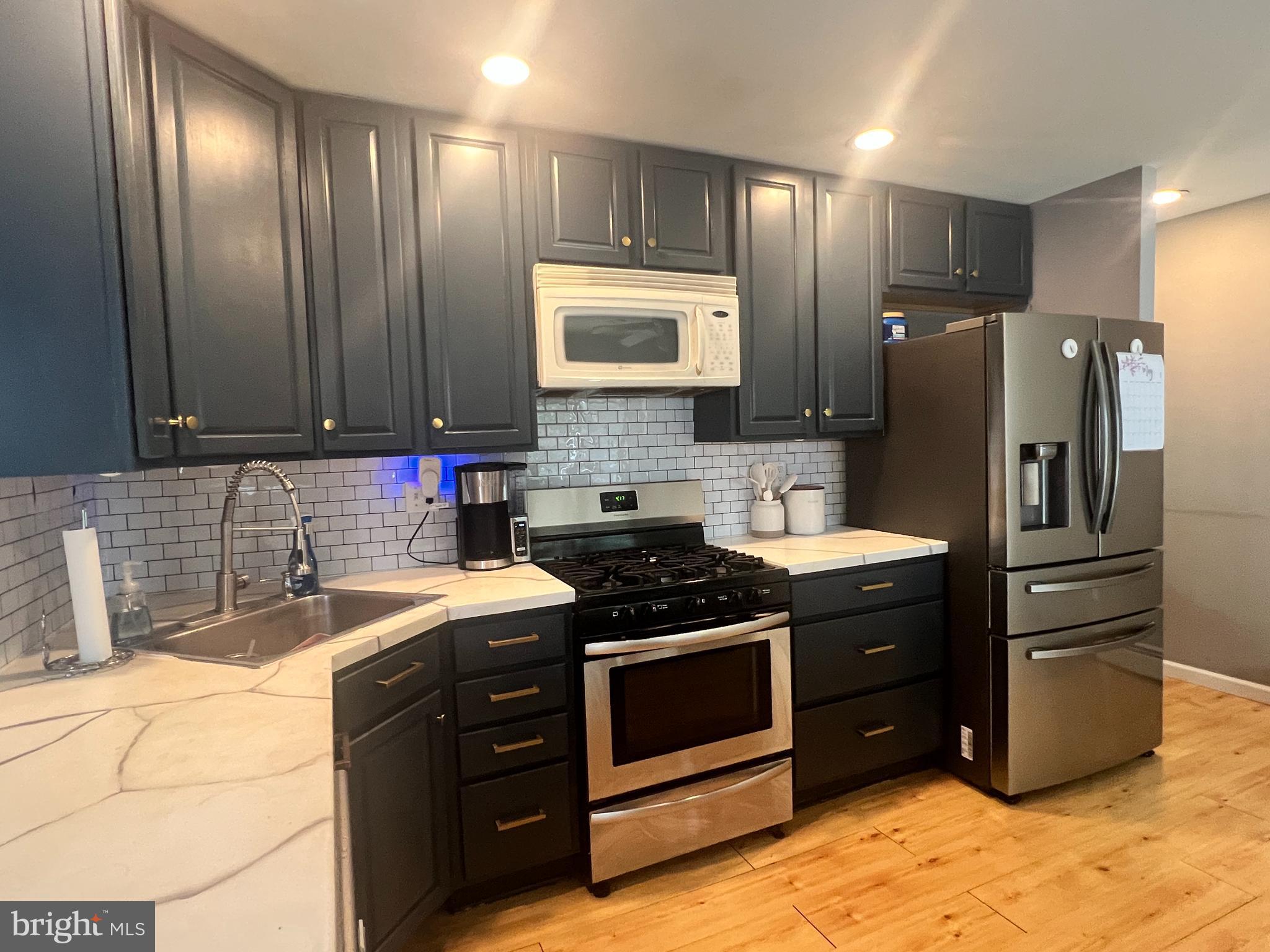 1075 Haverford Road Ridley Park, PA 19078 - Photo 5 of 14 a kitchen with stainless steel appliances granite countertop a sink stove and refrigerator