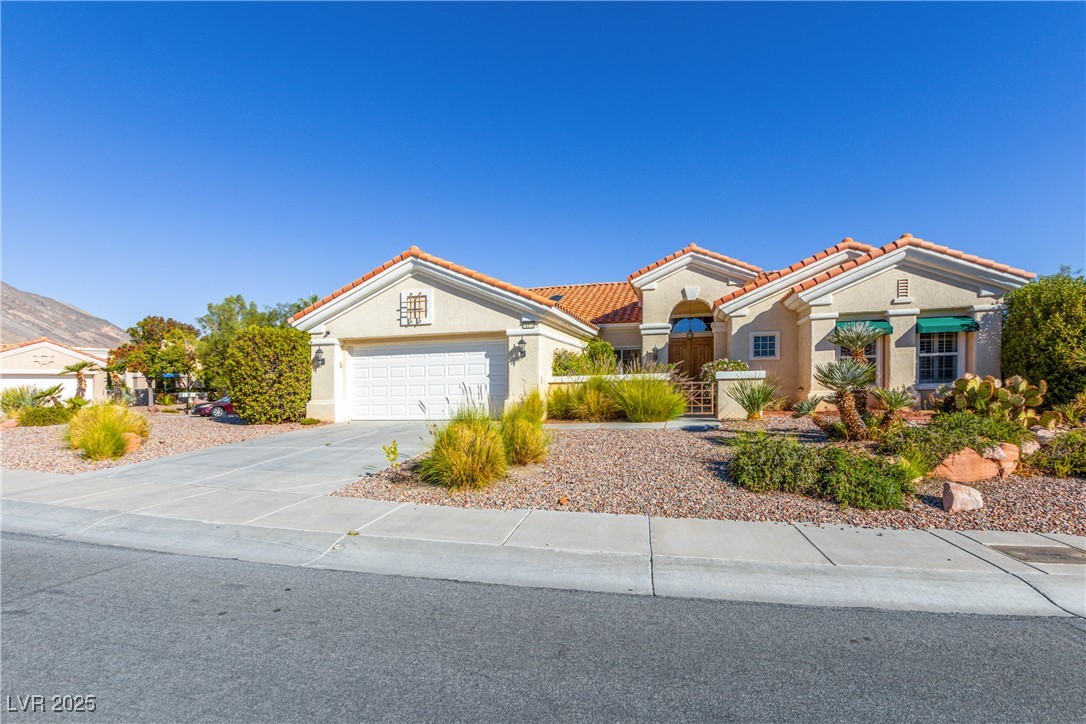 10548 Findlay Avenue Las Vegas, NV 89134 - Photo 4 of 27 Mediterranean / spanish-style home with stucco siding, driveway, an attached garage, and a tile roof