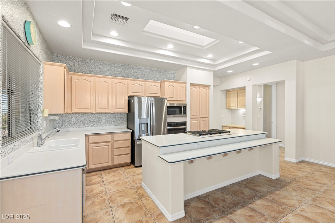 10548 Findlay Avenue Las Vegas, NV 89134 - Photo 10 of 27 Kitchen with light brown cabinets, appliances with stainless steel finishes, a center island, light countertops, and recessed lighting