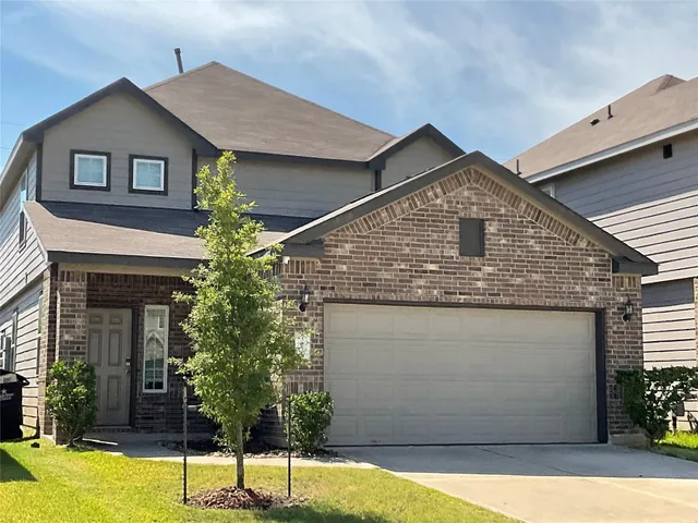 a front view of a house with a yard garage and outdoor seating