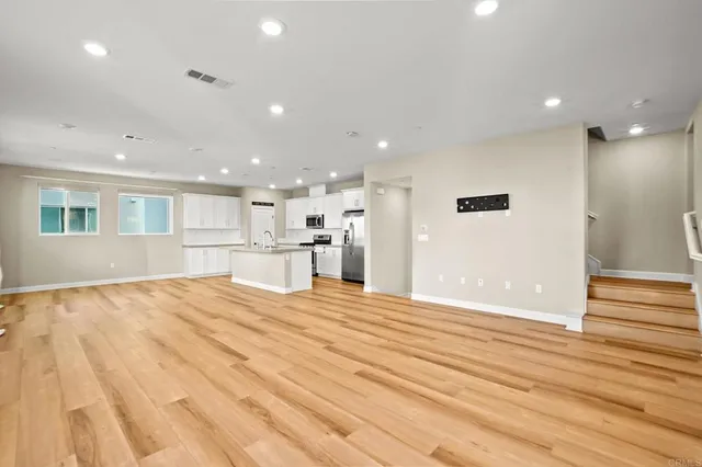 a kitchen with kitchen island a refrigerator sink and white cabinets