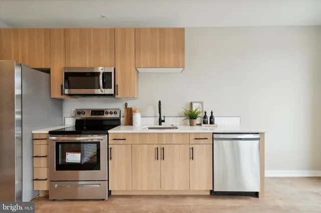 a kitchen with stainless steel appliances a stove a microwave a sink and cabinets