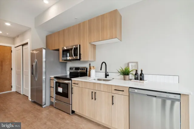 a kitchen with white cabinets sink and refrigerator