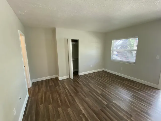 a kitchen with granite countertop a refrigerator a sink a stove and white cabinets