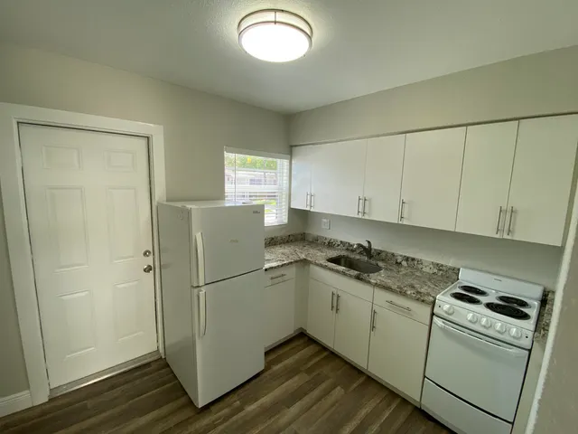a view of a kitchen with wooden floor and windows