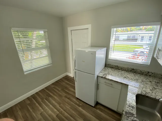 a kitchen with cabinets a stove and wooden floor
