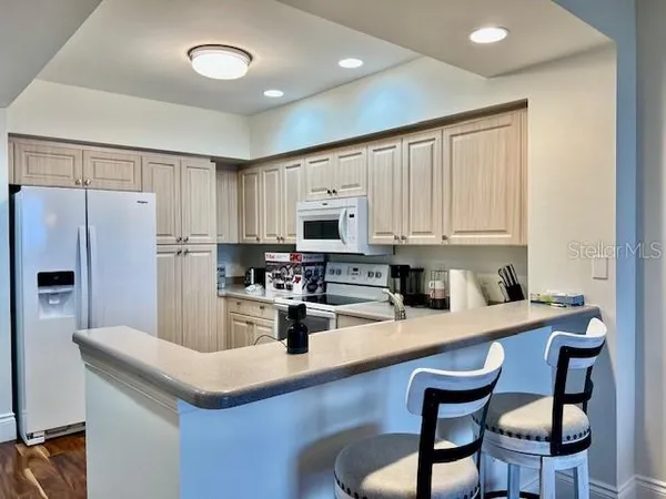 a living room with furniture and a view of kitchen
