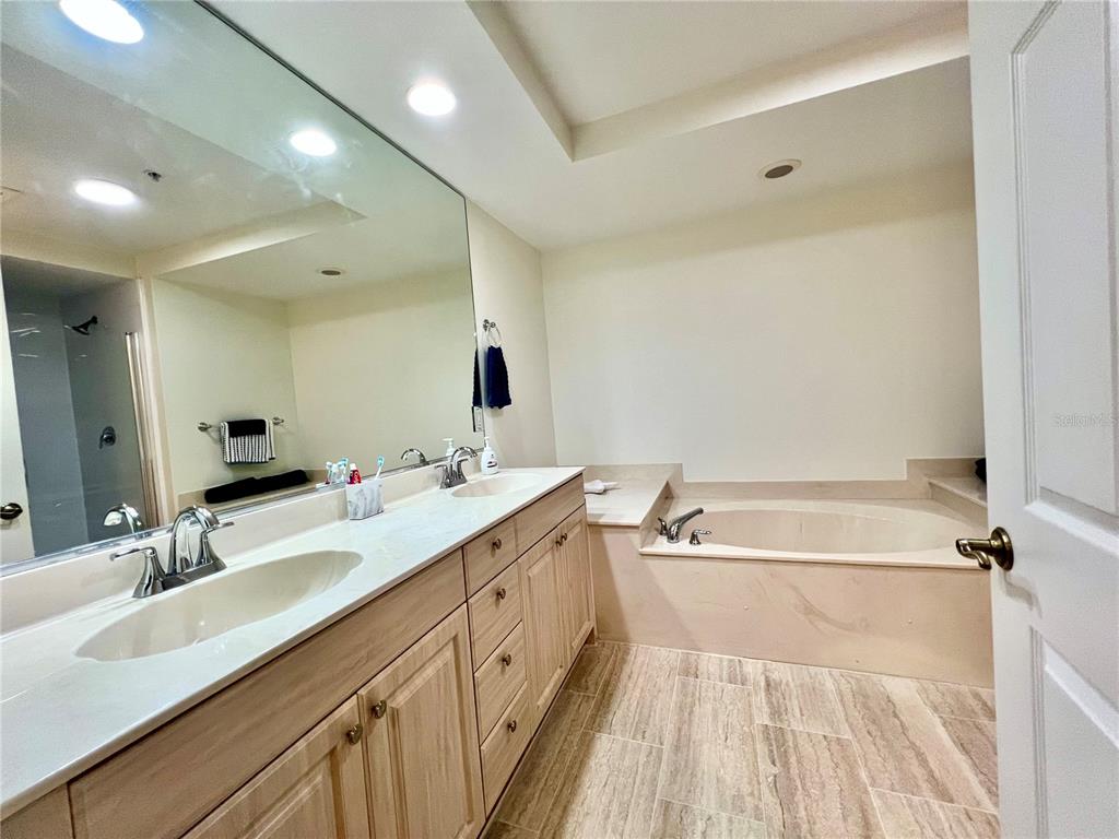 3191 Matecumbe Key Road, Unit 206 Punta Gorda, FL 33955 - Photo 20 of 45 a spacious bathroom with a double vanity sink a mirror and a bathtub