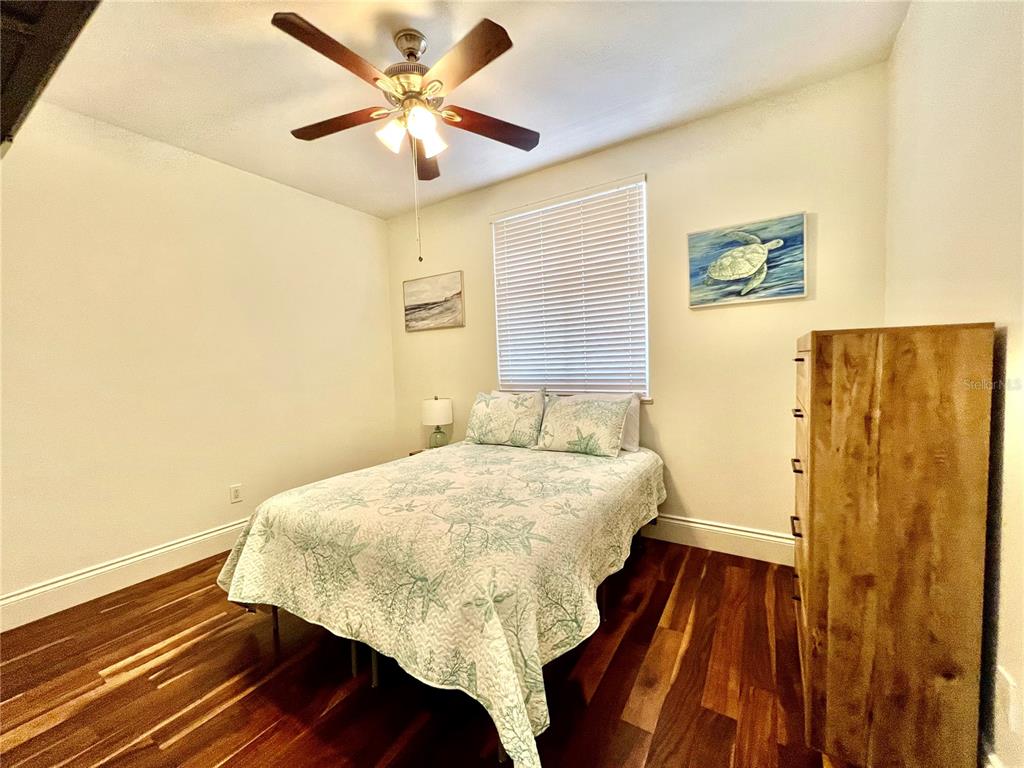 3191 Matecumbe Key Road, Unit 206 Punta Gorda, FL 33955 - Photo 24 of 45 a bedroom with a bed and wooden floor