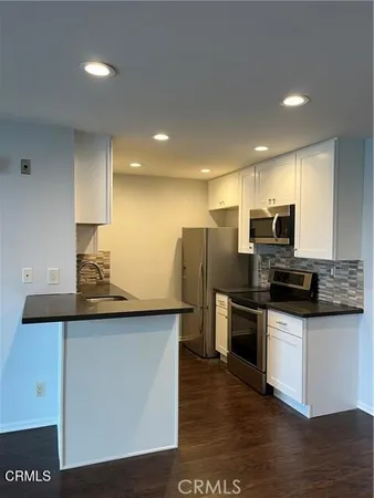 a kitchen with granite countertop white cabinets and white appliances