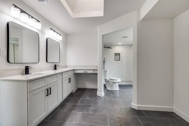 a spacious bathroom with a double vanity sink mirror and toilet