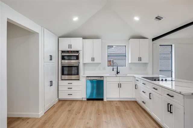 a kitchen with stainless steel appliances a stove sink and cabinets
