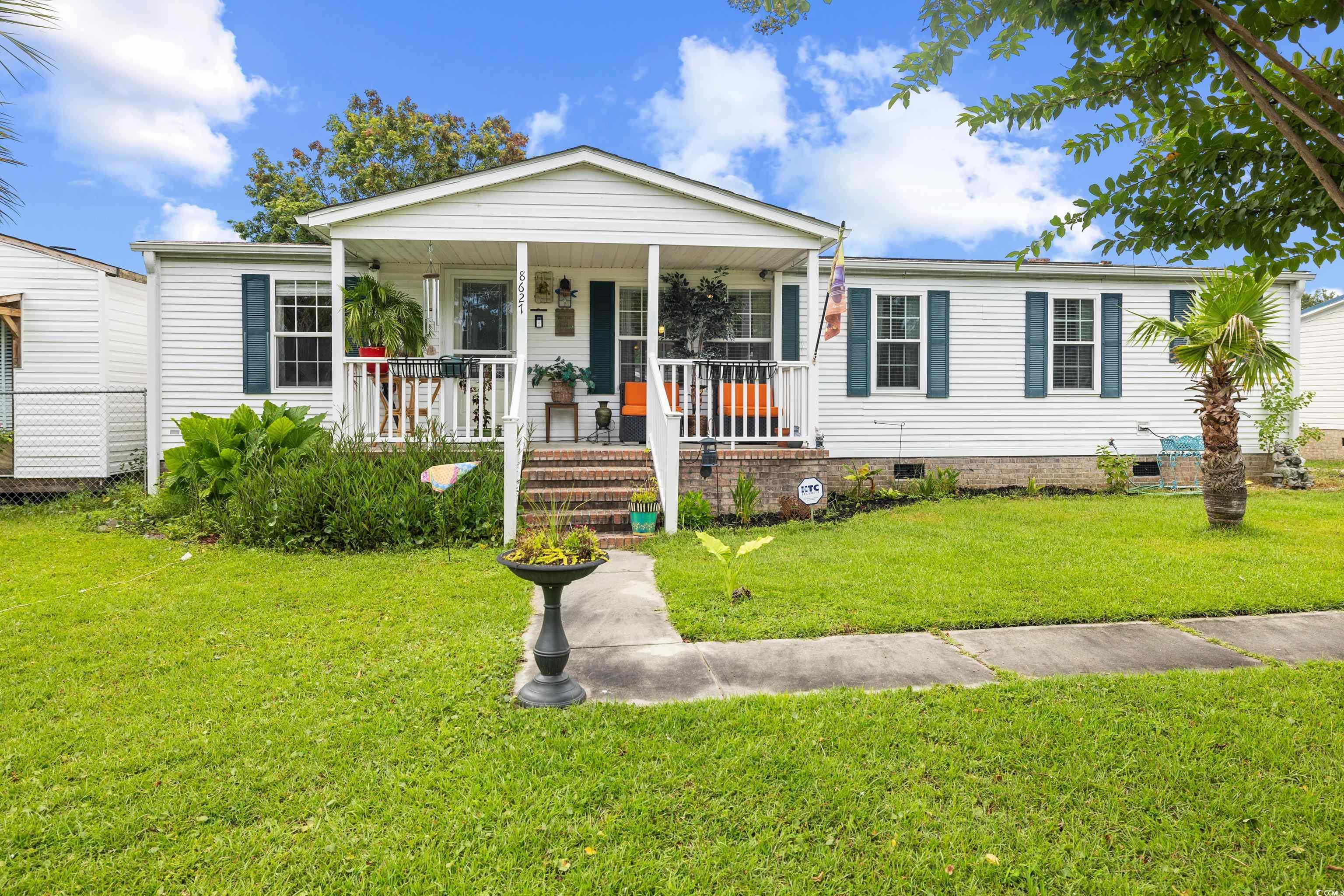 View of front of house with crawl space, a porch, and a front lawn