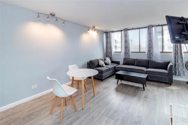a living room with furniture and a wooden floor