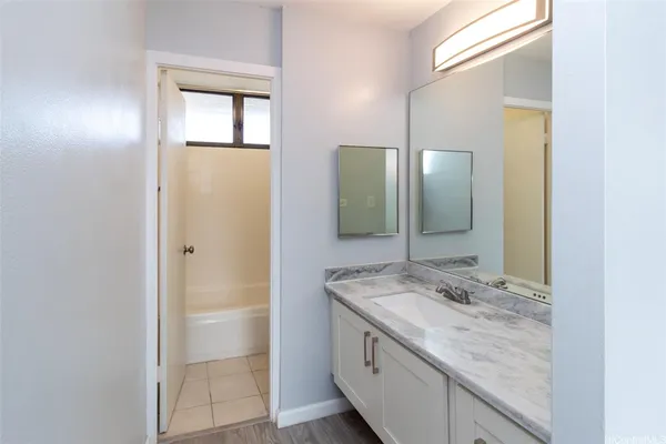 a bathroom with a granite countertop sink and a mirror