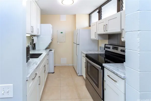 a kitchen with white cabinets and a stove