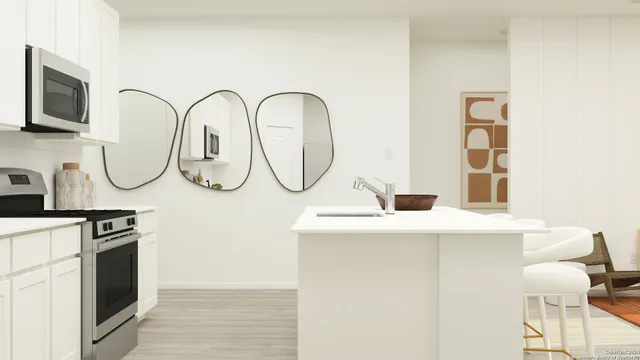a view of a kitchen with a sink and a stove top oven with a bookshelf