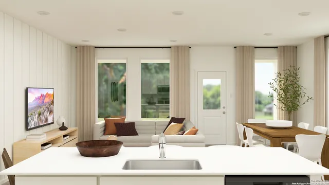 a living room with furniture a large window and a potted plant