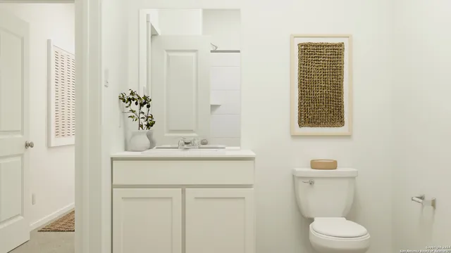 a bathroom with a toilet sink and mirror
