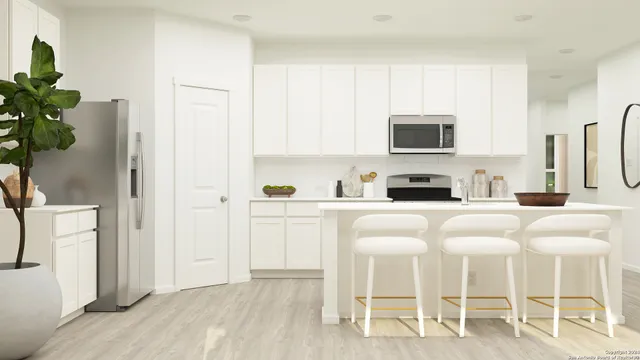 a white kitchen with stainless steel appliances granite countertop a white cabinets and a stove top oven