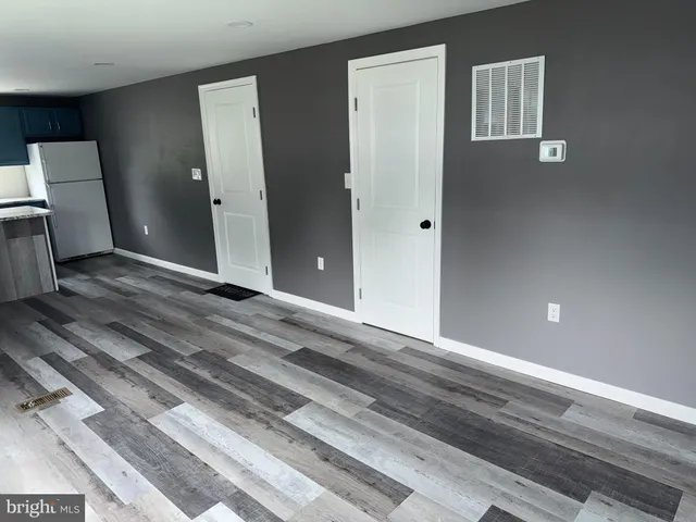 a view of a livingroom with wooden floor and electronic appliances