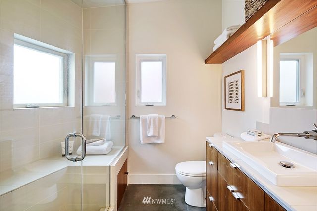 a bathroom with a sink a toilet and mirror