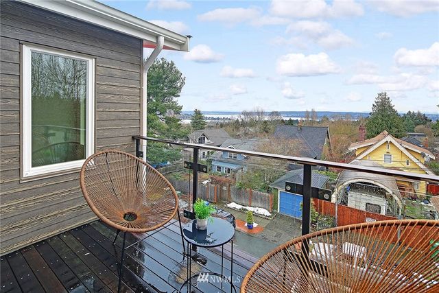 a view of a balcony with chairs and a potted plant