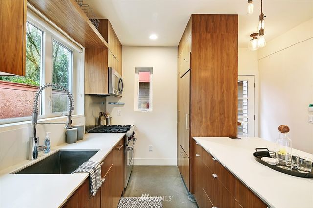 a kitchen with a sink stove top oven and cabinets