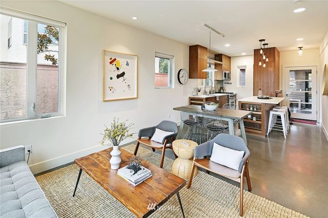 a living room with furniture kitchen view and a large window