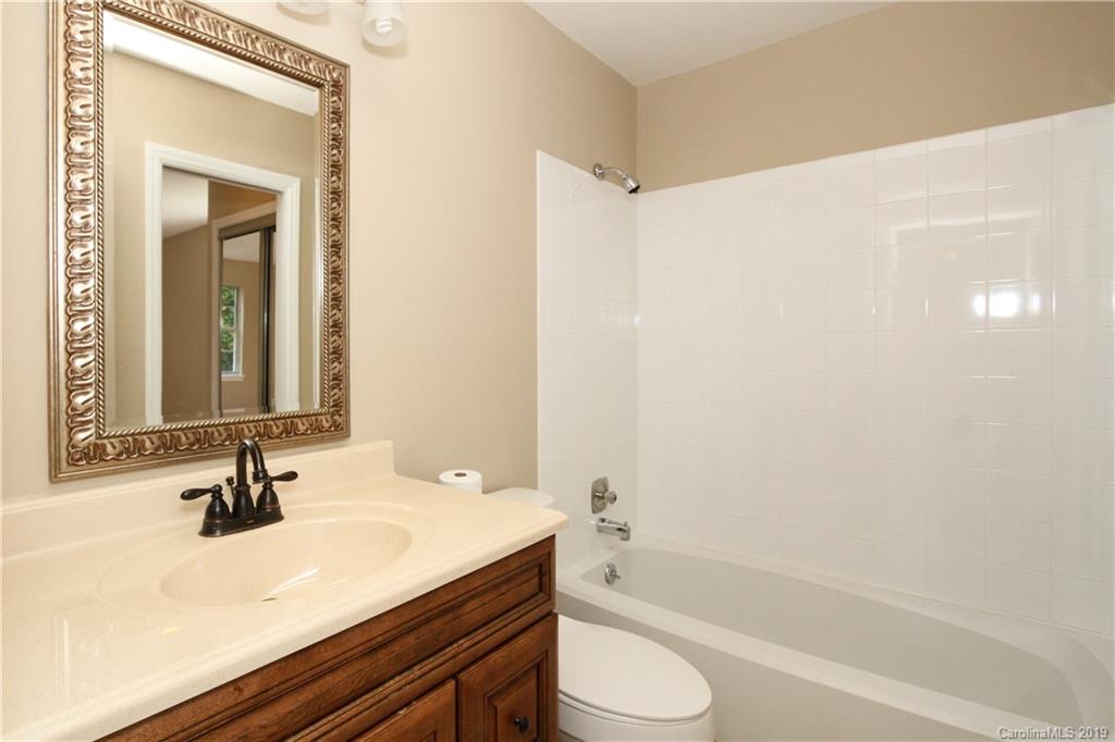 7825 Renaissance Court, Unit B Charlotte, NC 28226 - Photo 14 of 21 a bathroom with a bathtub shower sink vanity and toilet