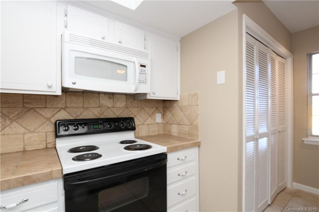 7825 Renaissance Court, Unit B Charlotte, NC 28226 - Photo 7 of 21 a kitchen with a stove and a microwave