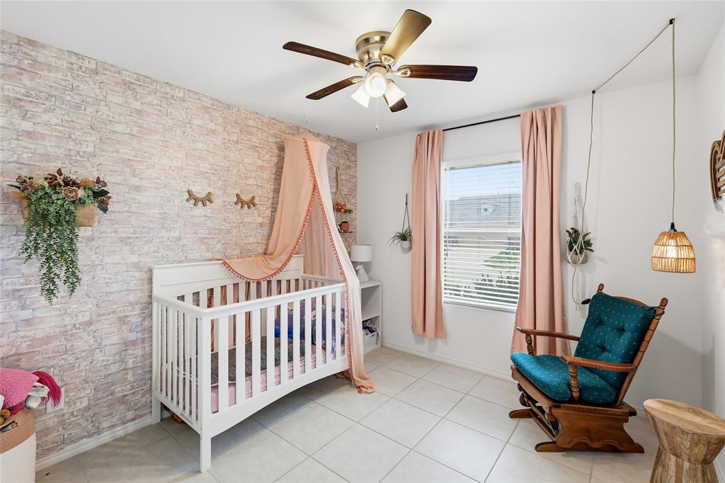 312 Ranchito Pass Fort Worth, TX 76052 - Photo 26 of 30 Bedroom featuring brick wall, a crib, a ceiling fan, and light tile patterned floors