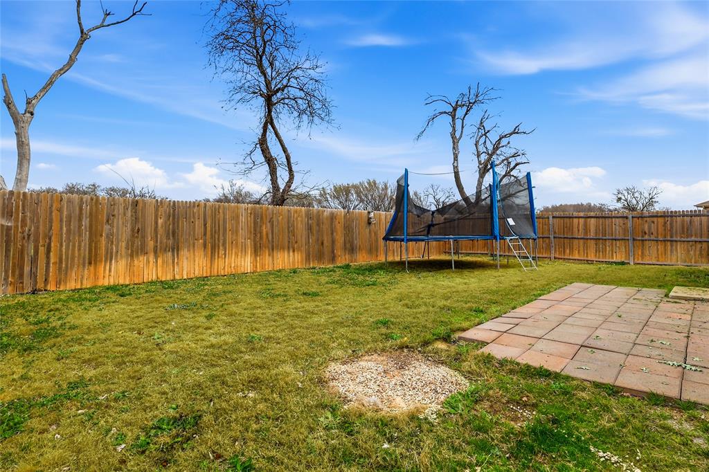 312 Ranchito Pass Fort Worth, TX 76052 - Photo 27 of 30 Fenced backyard featuring a trampoline and a patio
