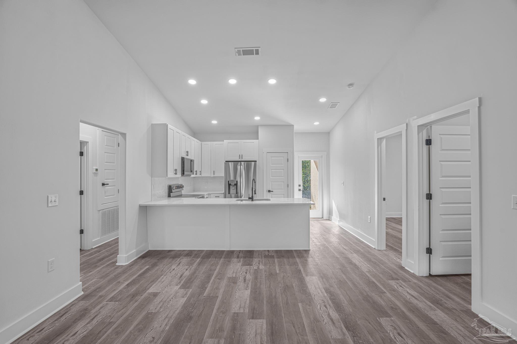 5005 Saufley Field Road Pensacola, FL 32526 - Photo 3 of 27 a kitchen with stainless steel appliances a refrigerator and wooden floor
