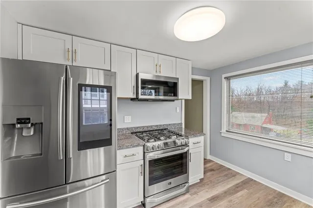 a kitchen with a granite countertop sink and cabinets