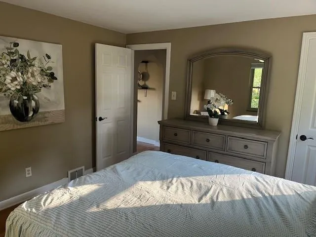 a bedroom with a bed and wooden floor