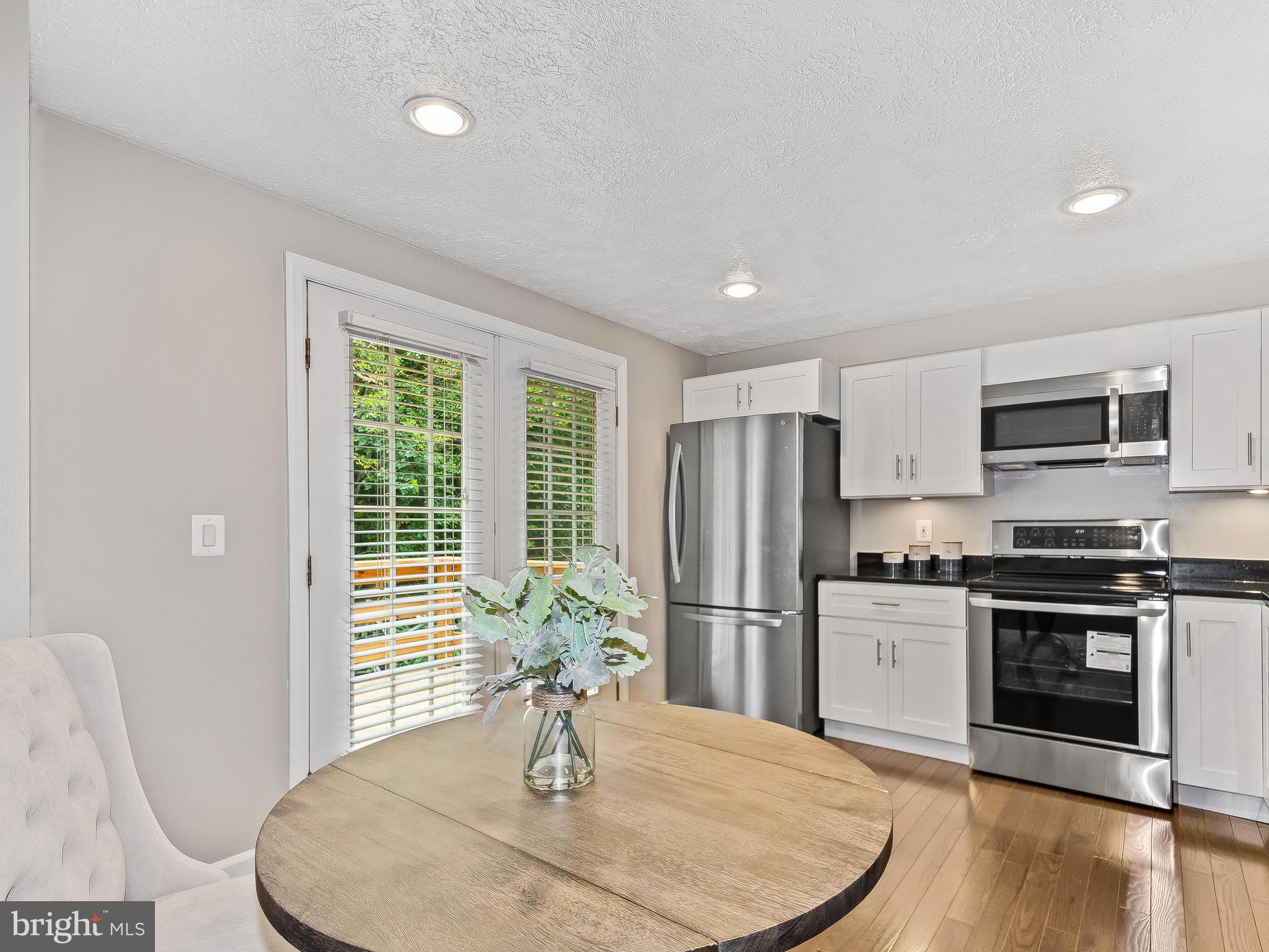 1931 Sagewood Lane Reston, VA 20191 - Photo 7 of 30 a kitchen with stainless steel appliances kitchen island granite countertop a refrigerator a stove a sink dishwasher with a dining table and chairs